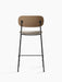 Back view of the Co Counter Chair, Seat Upholstered, with dark stained oak backrest, upholstered seat, and black frame.