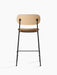 Back view of the Co Counter Chair with a natural oak backrest, a tan upholstered seat, and a slender black steel frame.