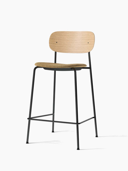 Co Counter Chair with a natural oak backrest, a seat upholstered in Audo Bouclé 06, and a black steel frame.