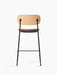 Rear view of the Co Counter Chair, Seat Upholstered, with natural oak backrest, light brown seat, and black steel frame.