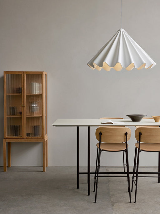 Minimalist dining room with two oak Co Counter Chairs at a Snaregade Table, a Dancing Pendant above and a Curiosity Cabinet.