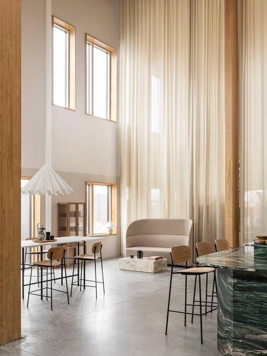 A bright room with a Tearoom Sofa, Plinth table, Snaregade table with Co Counter Chairs under a Dancing Pendant light.