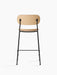 Back view of the Co Counter Chair, Veneer, showing its natural oak backrest and seat on a slender, powder-coated black frame.