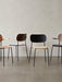 A line of four Audo CPH Co Dining Chairs showcasing various finishes, including wood veneers, black lacquer, and upholstery.