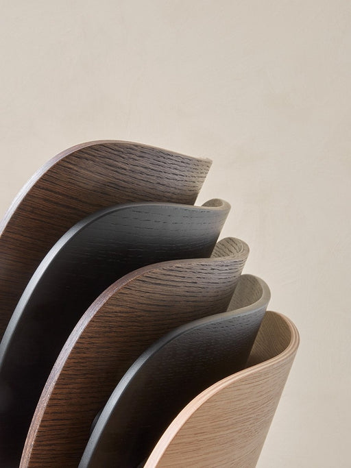 Detailed shot of the curved veneer backrests of several Co Dining Chairs, highlighting the different oak finishes available.