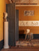 A stack of four ivory Co Dining Chairs, Outdoor, in an elegant, mustard-yellow room with classical bas-reliefs on the wall.