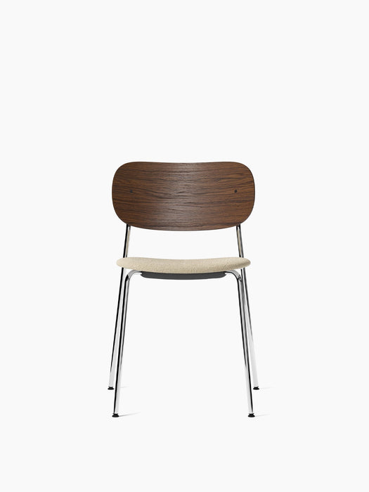 A front view of the Co Dining Chair with a dark stained oak backrest, a light bouclé upholstered seat, and a chrome frame.