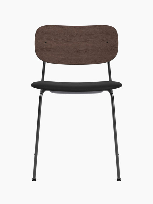 A front view of the Co Dining Chair with a dark stained oak backrest, a black upholstered seat, and a slender black frame