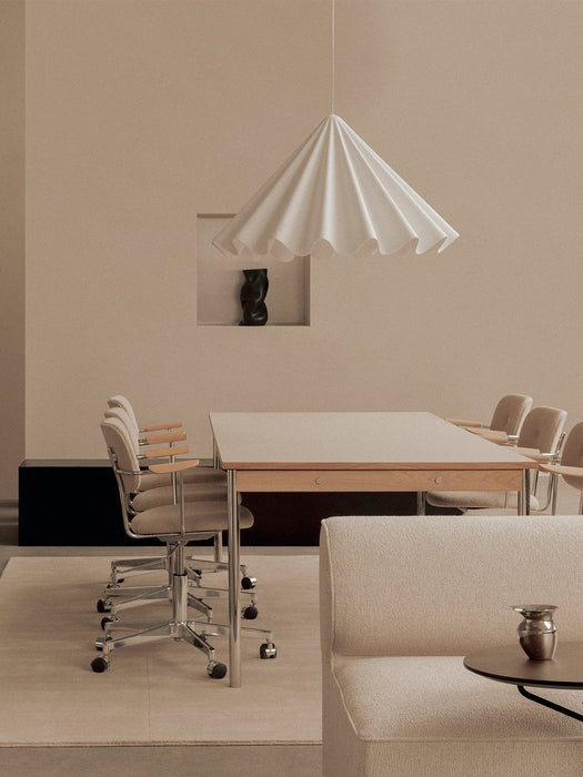 A beige meeting room with a Co Table and Co Task Chairs under a Dancing Pendant. An Eave Sofa is visible in the foreground.