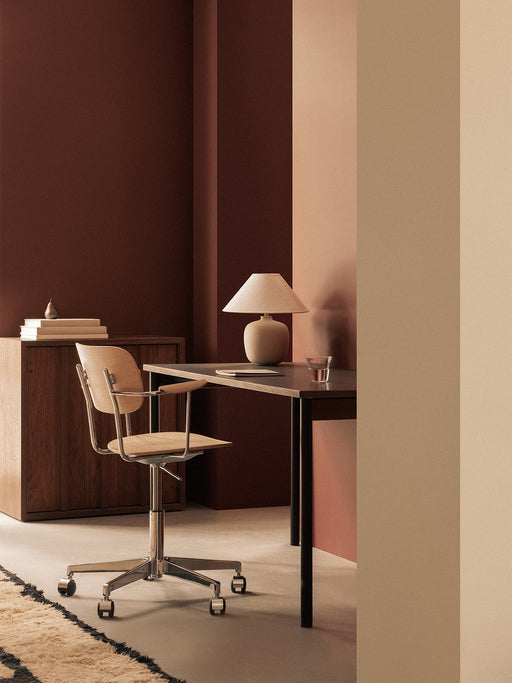 Home office with a Co Table, Co Task Chair, and Torso Table Lamp. A wooden cabinet holds books and a Sentiment Paperweight.