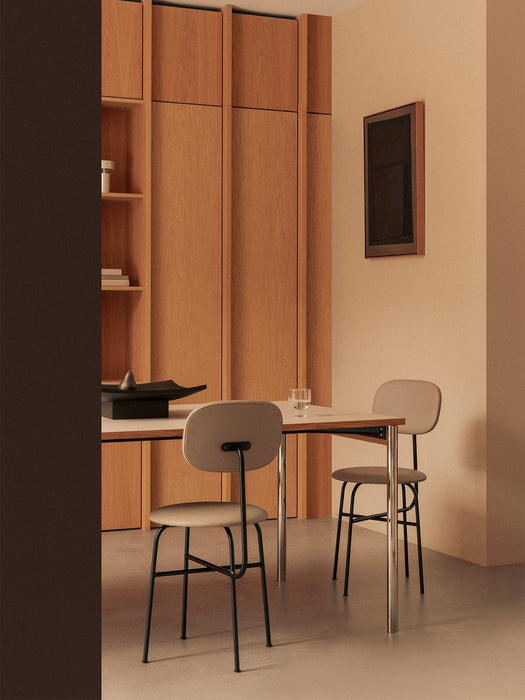 The Co Table is set with two Afteroom Dining Chairs in a minimalist room with oak wall cabinets and a black Releve Platter.