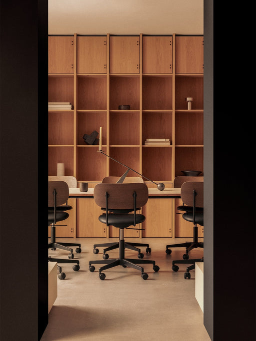 Office with Co Task Chairs at a Co Table. A background bookcase displays an Interconnect Candleholder and Column Lamp.