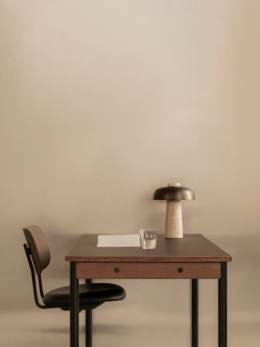 A Co Task Chair is neatly placed at a dark wood Co Table, accessorised with a Reverse Table Lamp and a glass of water.