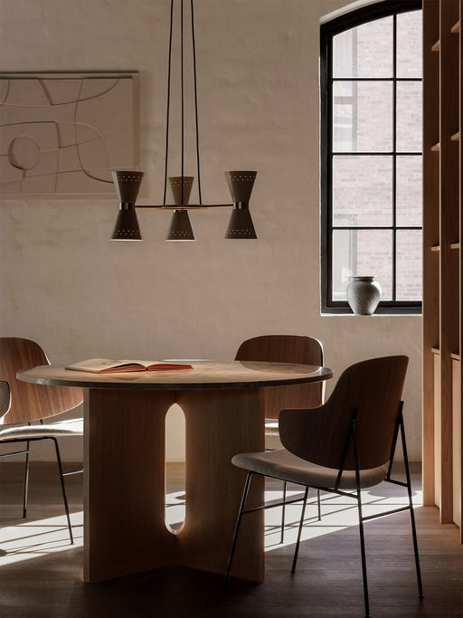 A Collector Chandelier, 3 hangs above a wooden Androgyne Dining Table and Penguin Chairs in a naturally lit dining room.