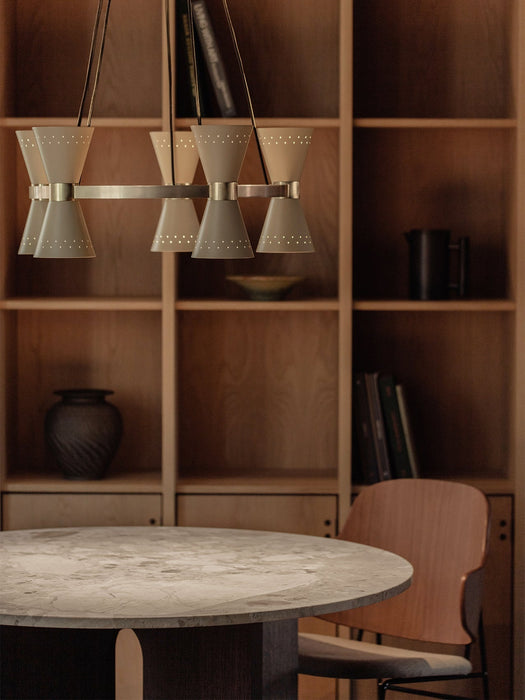 Side view of the Collector Chandelier, 5 hanging above a marble-topped Androgyne Dining Table and a Penguin Dining Chair.