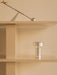Brushed aluminium Column Table Lamp, Portable on a beige shelf below an Interconnect Candle Holder in a minimalist setting.