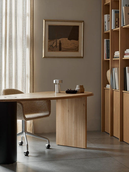 A silver Column Table Lamp sits on a wooden Eclipse Desk beside a Harbour Dining Chair in a stylish, modern home office.