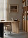 A silver Column Table Lamp sits on a wooden Eclipse Desk beside a Harbour Dining Chair in a stylish, modern home office.
