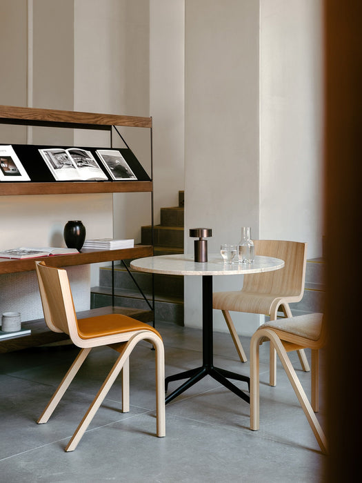 A Column Table Lamp sits on a marble Harbour Column Table with Ready Dining Chairs. A Zet shelving unit is in the background.