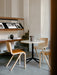 A Column Table Lamp sits on a marble Harbour Column Table with Ready Dining Chairs. A Zet shelving unit is in the background.