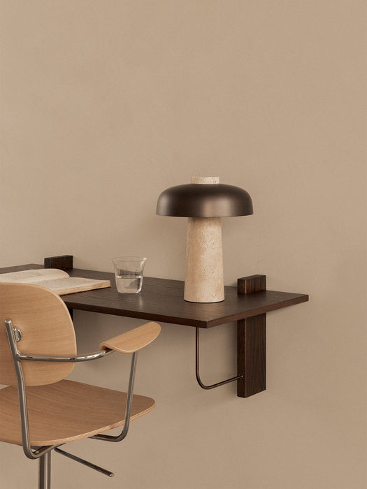A close-up, angled view of the dark wood Corbel Desk styled with a Reverse Table Lamp and a light wood Co Task Chair.
