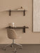 A home office featuring a dark oak Corbel Desk, a beige Harbour Side Chair with a caster base, and a marble Corbel Shelf.