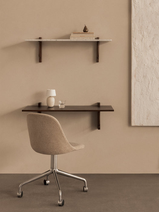 A workspace featuring a dark wood Corbel Desk, marble Corbel Shelf, beige Harbour Chair on casters, and a Torso Table Lamp.