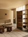 A living room with a Radiohus Sofa, Androgyne Side Tables with an Interconnect lamp, a Tile Rug, and Crescent Shelving.