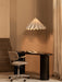 A white Dancing Pendant Lamp hangs over a black Eclipse Desk and a Co Task Chair in a warmly lit office with beige walls.