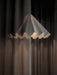An artistic shot of the white Dancing Pendant Lamp, its glowing, pleated shade partially veiled by a sheer dark curtain.