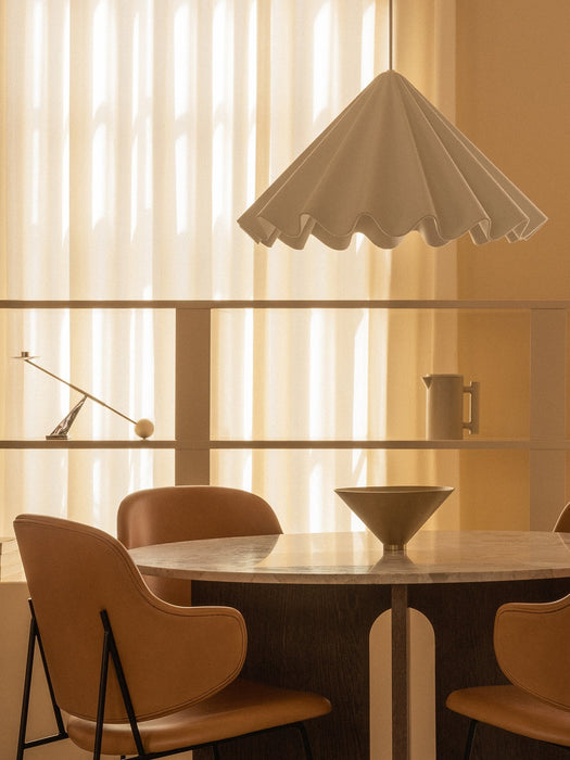A dining room featuring a white Dancing Pendant Lamp over an Androgyne Dining Table, Penguin Dining Chairs and a Taper Bowl.