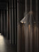 The white Dancing Pendant Lamp is seen partially obscured by a dark, sheer curtain, casting a warm glow in a dimly lit room.