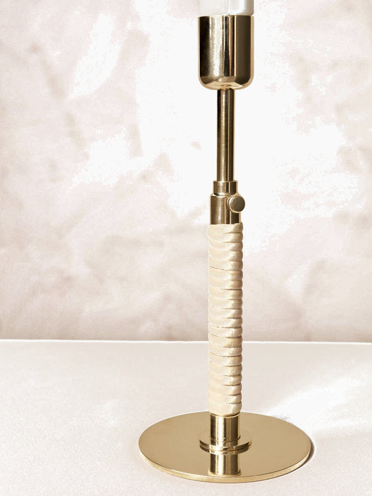 A detailed close-up of the Duca Candlestick highlighting the polished brass finish and the intricately wrapped rattan handle.