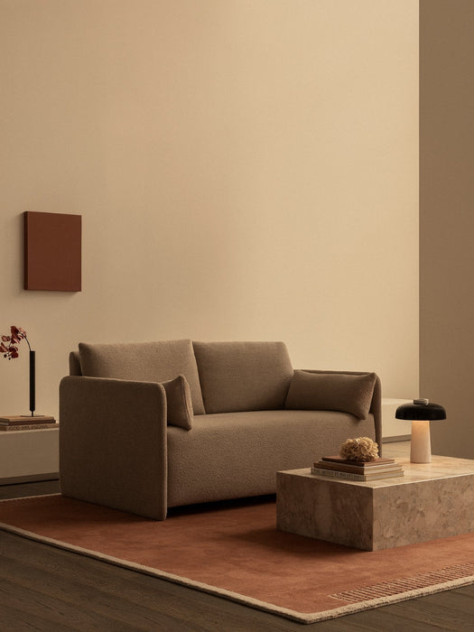 A minimalist living room featuring the brown Offset Sofa Bed, a Plinth Low marble table with a Reverse Lamp, on a Duomo Rug.
