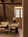 A cosy attic room with a Brasilia Sofa & Lounge Chair, Torso Table Lamp, Interconnect Candle Holder on a Duomo Rug.