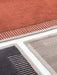 A detailed close-up of the Duomo Rug in three colours—terracotta, charcoal and beige—showing the textured striped border.