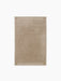 A top-down view of the rectangular Duomo Rug in Limestone Beige, showing a solid-coloured body and decorative ribbed borders.