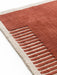 A close-up of the Duomo Rug in Terracotta Red, showing its woven texture, beige border, and pattern of raised stripes.