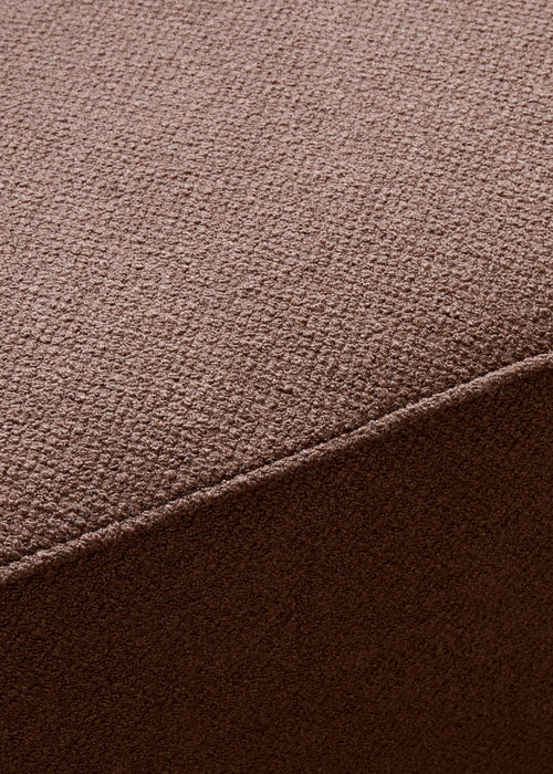 A close-up shot of the textured brown Audo Bouclé fabric of the Eave Modular Sofa Pouf, highlighting its looped weave.