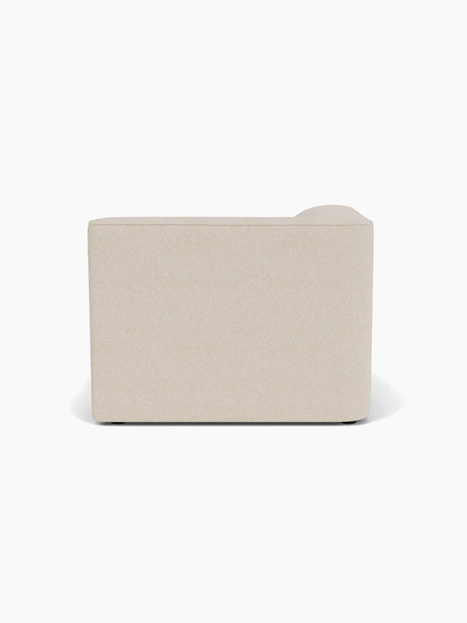Back view of the Eave Modular Sofa, 96, Chaise Longue, upholstered in a light-coloured fabric against a white background.