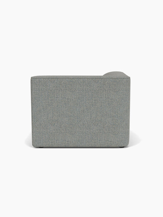 Back view of the Eave Modular Sofa, 96, Chaise Longue, upholstered in a textured, light grey Safire 12 fabric.