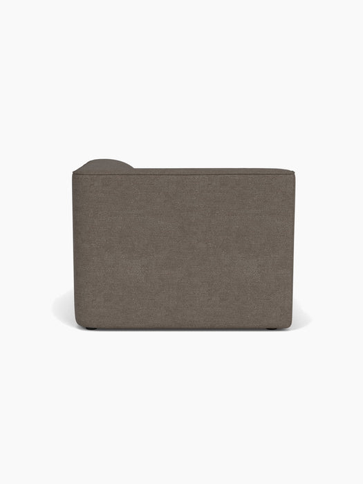 A back view of the Eave Modular Sofa, 96, Chaise Longue upholstered in a dark textured fabric, isolated on white background.
