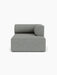 A front-on view of the grey, textured Eave Modular Sofa, 96, Chaise Longue, featuring a deep seat and a low, curved backrest.