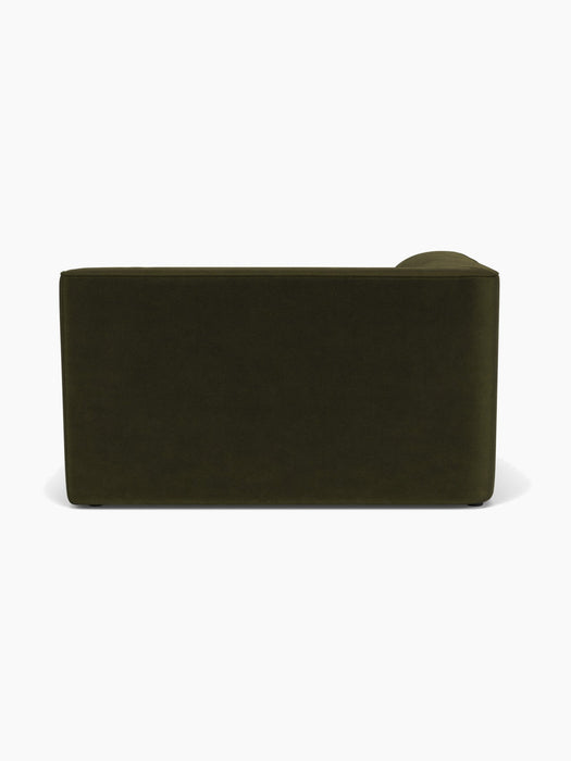 A back view of the Eave Modular Sofa, 96, Corner 144. The minimalist sofa is upholstered in a dark olive green fabric.