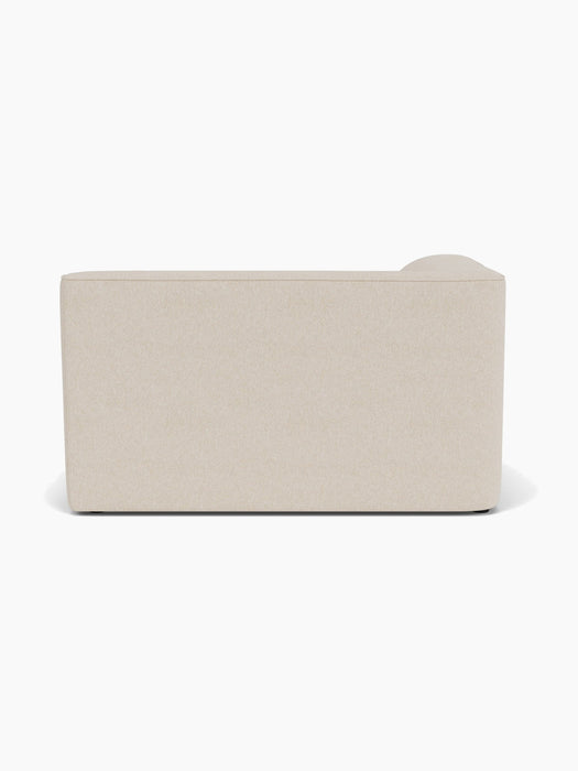 Rear view of the Eave Modular Sofa, 96, Corner 144 module, upholstered in a pale, textured fabric against a white background.