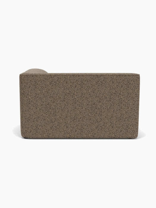 A back view of the Eave Modular Sofa, 96, Corner 144, upholstered in a textured, brown Safire fabric against a background.