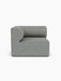 A front view of the Eave Modular Sofa, 96, Corner Left module, upholstered in a textured, mottled grey Safire 012 fabric.