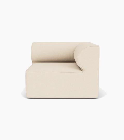 The Eave Modular Sofa, 96, Corner unit, seen from the front. It features a blocky base and a curved armrest in light fabric.
