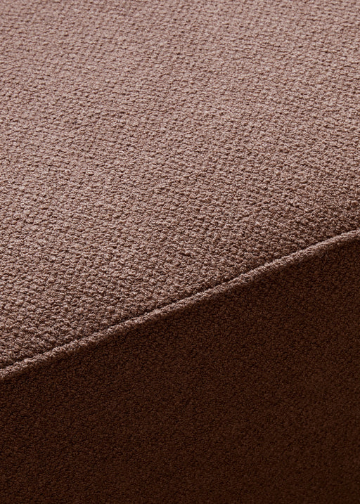A close-up, detailed shot of the brown textured bouclé fabric on the Eave Modular Sofa, 96, Pouf, showing a corner seam.