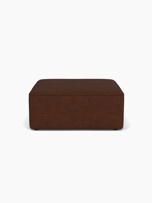 Front view of the Eave Modular Sofa Pouf, 96, upholstered in dark brown Audo Bouclé 08 fabric, on a white background.